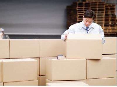 ダンボールを積んでいる男性